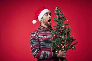 emotional man Christmas tree toys New year red background photo