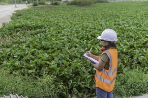 los ingenieros ambientales trabajan en la planta de almacenamiento de agua, verifican el ph del agua, verifican la calidad del agua. foto