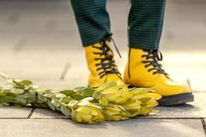 De las mujeres pies en amarillo zapatos. allí es un ramo de flores de amarillo flores cercano. el concepto de el primavera fiesta - marzo 8, Pascua de Resurrección, De las mujeres día foto