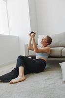 Happy smile woman holding an old camera and taking pictures of herself as a weekend photographer in home clothes with a short haircut hair without filters on a white background, free copy space photo