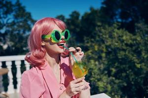 cheerful woman in pink dress outdoors with cocktail Relaxation concept photo