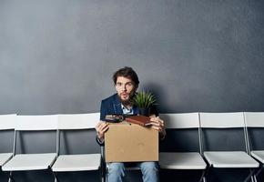 Man sits on a chair box with things dismissing discontent depression photo