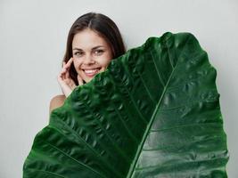 smiling woman green palm leaf cropped view Studio photo