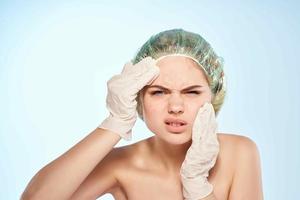 woman in pink towel gloves squeezes pimples dermatology photo