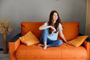 hermosa mujer relajante a hogar en el habitación en el sofá interior apartamentos foto