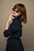 Charming brunette touches her face with her hand and looks ahead black coat Copy spaces photo