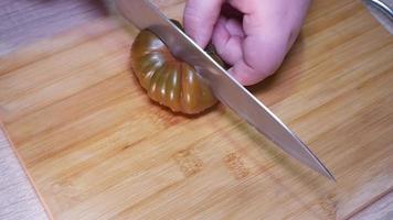 femme Coupe une tomate avec une couteau video