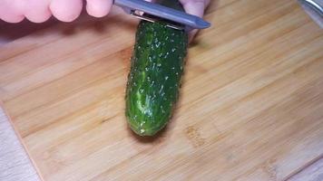 Woman peeling a cucumber closeup video