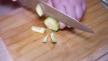 Woman cutting cucumber with a knife video