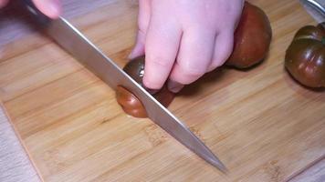 femme Coupe une tomate avec une couteau video