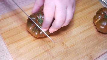 femme Coupe une tomate avec une couteau video