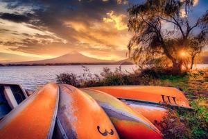 Mt. Fuji over Lake Kawaguchiko with boats at sunset in Fujikawaguchiko, Japan. photo