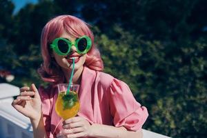 fashionable woman in pink dress outdoors with cocktail Relaxation concept photo