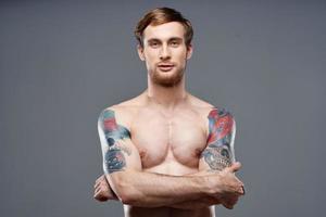 retrato de un deportivo hombre con un mejorado torso tatuaje rubio modelo recortado ver foto