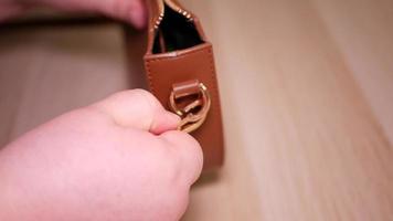 A woman's hand unhooks a carabiner on a small women's bag video