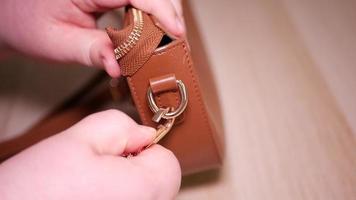 A woman's hand unhooks a carabiner on a small women's bag video
