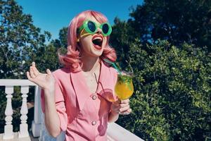 cheerful woman enjoying a colorful cocktail hotel terrace Summer day photo