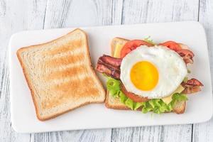 Sandwich with fried egg and bacon photo