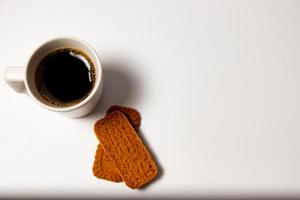 Cup of coffee and cookies on a white background, top view photo