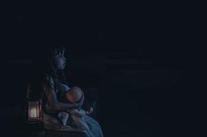 triste niño fantasma a noche de halloween festival concepto, viernes 13, terror película escena,a niña con muñeca foto