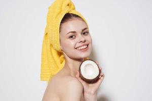 cheerful woman behind an animal with a towel on her head with a coconut in her hands exotic fruits natural cosmetics photo