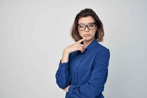 Business woman in blue shirt wearing glamor glasses posing light background photo