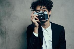 guy holding a camera in his hand retro classic suit curly model man photo