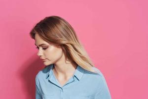 pretty blonde in blue shirt cosmetics pink background photo