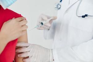 doctor injecting an injection into the shoulder coronavirus vaccination close-up photo