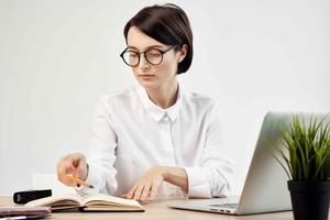 Businesswoman at the desk with glasses self-confidence light background photo