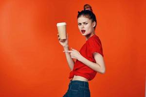 alegre mujer en rojo camiseta con taza de café recortado ver aislado antecedentes foto