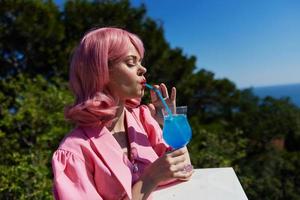 Young female enjoying a colorful cocktail hotel terrace Drinking alcohol photo