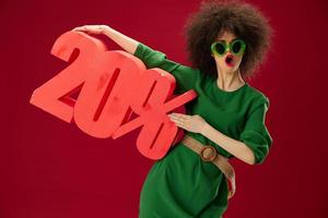 pretty woman green dress afro hairstyle dark glasses twenty percent in hands color background unaltered photo