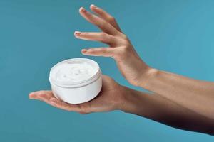 jar of cream in hands dermatology skin care cosmetics photo