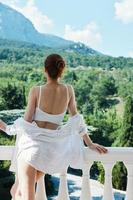 attractive young woman stands on a balcony terrace in lingerie sunlight beautiful view unaltered photo