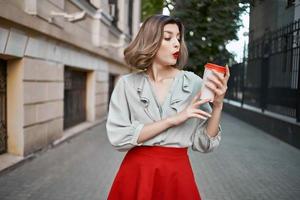 rubia mujer en rojo falda al aire libre taza de café divertido foto