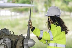 técnico arreglando el motor del avión, ingeniería aeroespacial femenina revisando los motores de los aviones, el mantenimiento mecánico asiático inspecciona el motor del avión foto