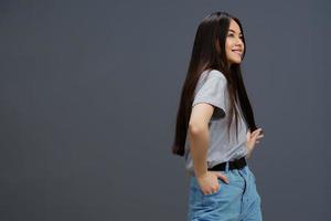 bonito mujer con largo pelo en un gris camiseta gesticulando con manos aislado antecedentes foto