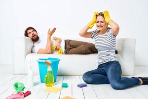 The wife cleans up while the husband lies on the couch interior housework photo