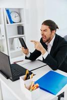 Man at the desk documents communication by phone Lifestyle photo