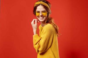 pretty woman in yellow sweater glasses fashion emotions red background photo