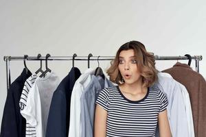 pretty woman next to clothes fashion fun isolated background photo