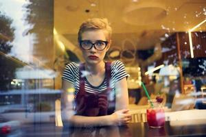 woman with short hair sitting in a restaurant cocktails leisure lifestyle photo