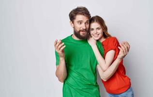 man and woman in multicolored t-shirts embrace studio photo