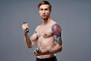 athletic man with dumbbells in the hands of a workout photo