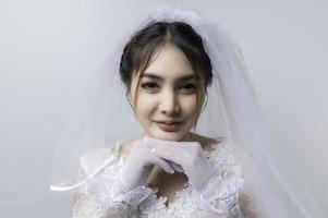 retrato de asiático mujer vestir novia con flor en blanco fondo, boda concepto foto