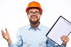Cheerful workers orange paint documents construction industry light background photo