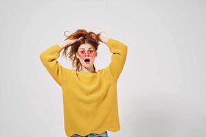 hermosa mujer en un amarillo suéter peinado Moda lentes ligero antecedentes foto