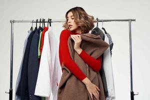 cheerful woman next to clothes fashion fun retail isolated background photo