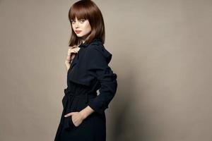 Gorgeous woman in a black coat bright makeup side view free place photo